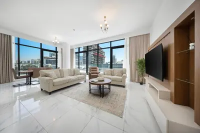 a living room with couches and a flat screen tv at Stylish 1BR with large Terrace JVC in Dubai