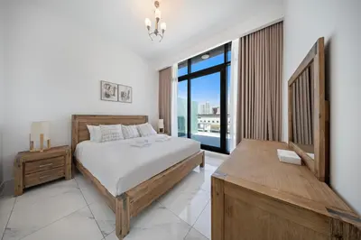 a bedroom with a bed and a large window at Stylish 1BR with large Terrace JVC in Dubai