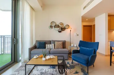 a living room with a couch and a table and chairs at Emaar 5242 - Stunning Sea View Stay in Prime Waterfront Location - Zed Living in Dubai