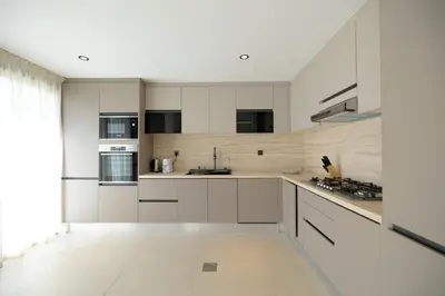 a kitchen with white cabinets and a large window at Designer Furnished Villa with Luxury Finishes in Springs 14 in Dubai