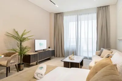 a living room with a couch and a tv at FAM Living Trillionaire Residences Premium Studio with Private Jacuzzi and Canal View in Dubai
