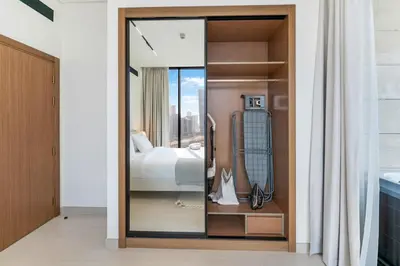 a bedroom with a bed and a glass door at FAM Living Trillionaire Residences Premium Studio with Private Jacuzzi and Canal View in Dubai