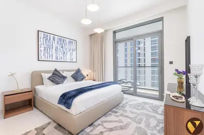 a white bedroom with a bed and a large window at Vogue Emaar Beach Front Marina Vista near JBR and Palm Jumeirah, Two Bedroom Apartment with Balcony and Private Beach, Access to all Amenities in Dubai
