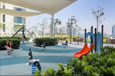 a playground with children playing on slides in a park at Vogue Emaar Beach Front Marina Vista near JBR and Palm Jumeirah, Two Bedroom Apartment with Balcony and Private Beach, Access to all Amenities in Dubai