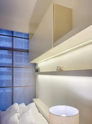 a bedroom with a bed and a table and a window at New Modern Japanese Style Studio by Downtown in Dubai