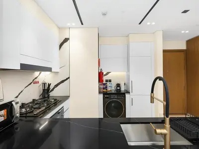 a kitchen with a black counter top and a dishwasher at Premium Burj Khalifa View & Private Jacuzzi in Dubai