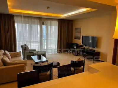 a living room with a couch and a television at Kempinski Central Avenue One Bedroom in Dubai
