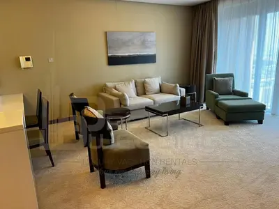 a living room with a couch and a table and chairs at Kempinski Central Avenue One Bedroom in Dubai