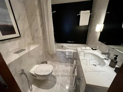 a bathroom with a sink and a toilet and a tub at Kempinski Central Avenue One Bedroom in Dubai