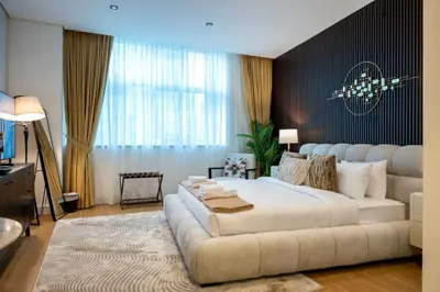 a bedroom with a large bed and a couch at Damac Maison - Impression by UDH in Dubai