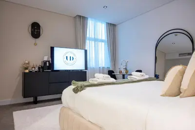 a hotel room with a bed and a television at Damac Maison - Impression by UDH in Dubai