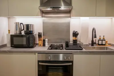 a kitchen with a stove and a microwave at Damac Maison - Impression by UDH in Dubai