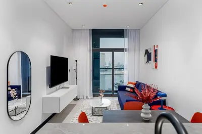 a living room with a tv and a mirror at Waves - Premium 1BR Apartment Overlooking Burj Khalifa in Dubai