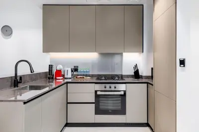 a kitchen with white cabinets and a stove top oven at Waves - Premium 1BR Apartment Overlooking Burj Khalifa in Dubai