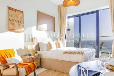 a bedroom with a bed and a table and chairs at Bloomfields Cozy Stu in Alexis Tower in Dubai
