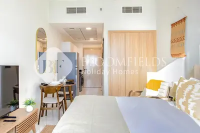 a bedroom with a bed and a desk and a table at Bloomfields Cozy Stu in Alexis Tower in Dubai