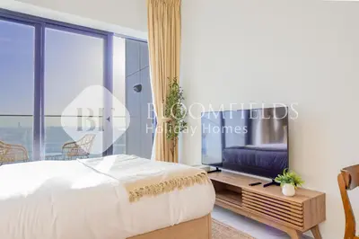 a bedroom with a bed and a large window at Bloomfields Cozy Stu in Alexis Tower in Dubai