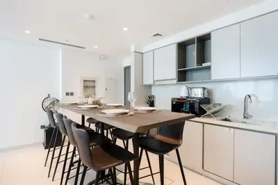 a kitchen with a long wooden table and chairs at Livbnb - Chic 1BR, Beachfront & Marina Views in Dubai