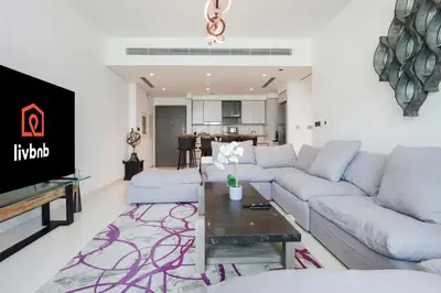 a living room with a couch and a table at Livbnb - Chic 1BR, Beachfront & Marina Views in Dubai