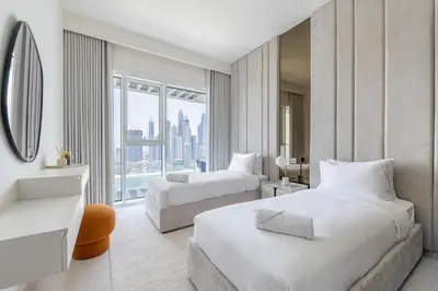 a hotel room with two beds and a large window at Designer 2-BR - Sea View - Grand Bleu by Elie Saab in Dubai