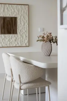 a white table with two chairs and a vase of flowers at Designer 2-BR - Sea View - Grand Bleu by Elie Saab in Dubai
