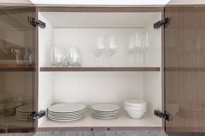 a cabinet filled with plates and wine glasses at Designer 2-BR - Sea View - Grand Bleu by Elie Saab in Dubai