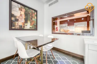 a dining room with a glass table and white chairs at Keysplease Upgraded 1 BR Apt near Dubai Mall, Burj Views in Dubai