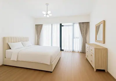 a bedroom with a bed and a dresser and a window at DreamShoma- Super Spacious 1BR Lake View in Dubai