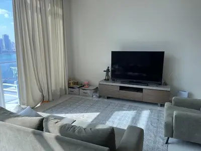 a living room with a couch and a flat screen tv at Oceana privat beach in Dubai