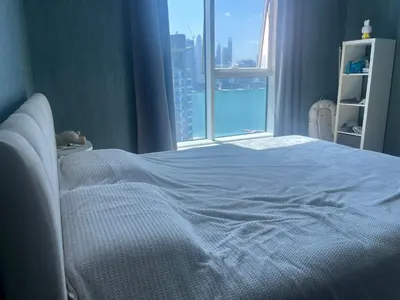 a bedroom with a white bed and a window at Oceana privat beach in Dubai