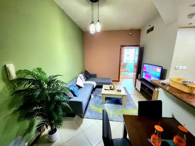 a living room with a couch and a tv at Diamond Marina Inn, Heart of Marina in Dubai