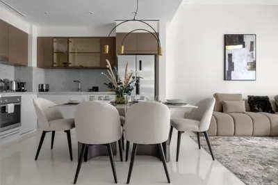 a kitchen with a dining room table and chairs at Palm-View 2BR Elie Saab Luxury in Dubai