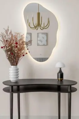 a table with a vase on it with a mirror at Palm-View 2BR Elie Saab Luxury in Dubai