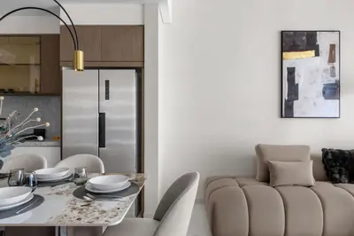 a dining room with a table and a couch at Palm-View 2BR Elie Saab Luxury in Dubai