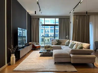 a living room with a couch and a tv at Elite Turnkey Residence 2BR in OIA Motor City 237 Dubai in Dubai