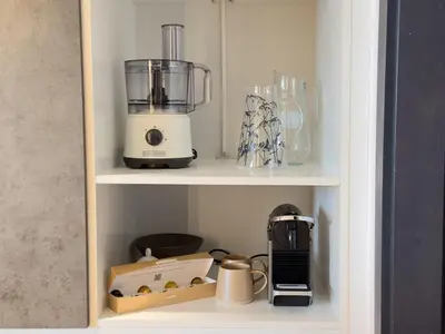 a kitchen cabinet with a blender and other items on it at Elite Turnkey Residence 2BR in OIA Motor City 237 Dubai in Dubai