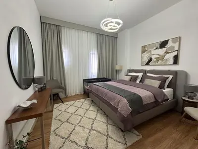 a bedroom with a large bed and a mirror at Elite Turnkey Residence 2BR in OIA Motor City 237 Dubai in Dubai