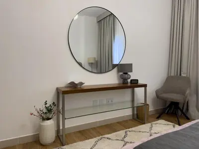 a bedroom with a mirror on the wall and a chair at Elite Turnkey Residence 2BR in OIA Motor City 237 Dubai in Dubai