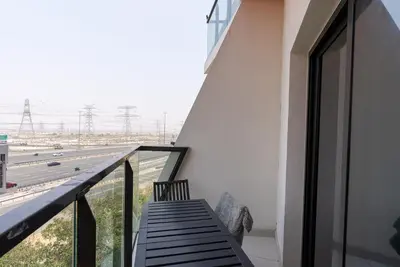 a balcony with a bench looking out at a highway at 1 Bedroom in JVC in Dubai