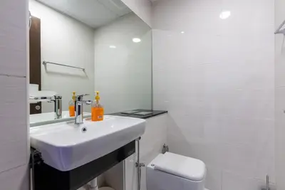 a white bathroom with a sink and a toilet at 1 Bedroom in JVC in Dubai