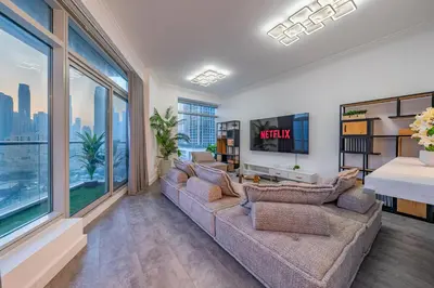 a living room with a couch and large windows at & Burj Luxury Living 2bhk Direct Burj Khalifa View in Dubai