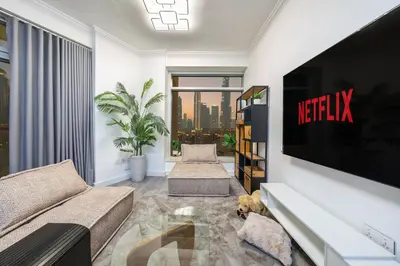 a living room with a couch and a tv at & Burj Luxury Living 2bhk Direct Burj Khalifa View in Dubai