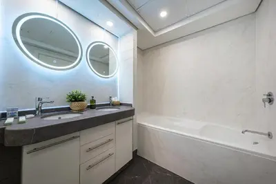 a bathroom with a sink and a tub and a mirror at & Burj Luxury Living 2bhk Direct Burj Khalifa View in Dubai