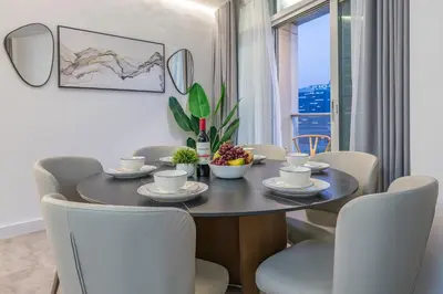 a dining room with a table and chairs and a window at & Burj Luxury Living 2bhk Direct Burj Khalifa View in Dubai