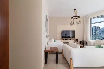 a living room with a white couch and a table at Beautiful Marina Views 1 Bed in Dubai