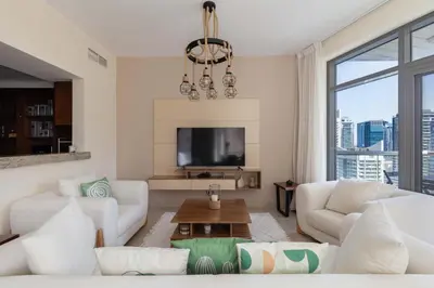 a living room with white furniture and a large window at Beautiful Marina Views 1 Bed in Dubai