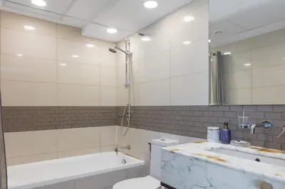 a bathroom with a tub and a toilet and a sink at Beautiful Marina Views 1 Bed in Dubai