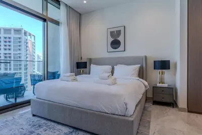 a bedroom with a large bed and a large window at TRPS - Peninsula Five, Business Bay - Stylish 1BR - Canal & Burj Khalifa Views in Dubai
