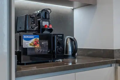 a microwave sitting on top of a kitchen counter at TRPS - Peninsula Five, Business Bay - Stylish 1BR - Canal & Burj Khalifa Views in Dubai