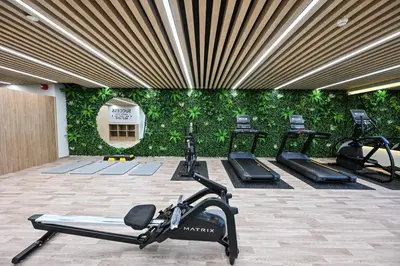 a gym with a row of exercise bikes in front of a green wall at Spacious 1 BHK with City Views Near Burj Khalifa in Dubai
